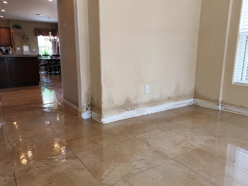 Water-damaged Las Vegas room with flood-cut walls and standing water before restoration